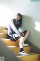 A young woman sitting on a set of stairs.