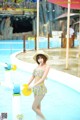 A woman in a yellow and blue bikini standing in a pool.