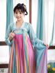 A woman in a blue and pink hanbok is posing for a picture.