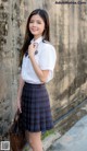 A young woman in a school uniform posing for a picture.