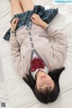 A woman laying on a bed wearing a school uniform.