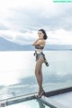 A woman standing on top of a glass railing next to a pool.