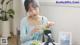 A woman sitting at a table with a plate of grapes.