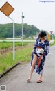 A woman walking down a road with a camera in her hand.